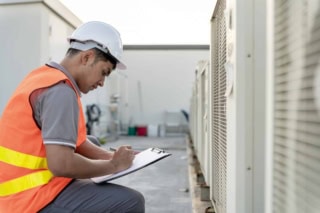 Asian maintenance engineer works on the roof of factory. contrac